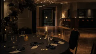 A school reunion at night, warm light and a crowded room.